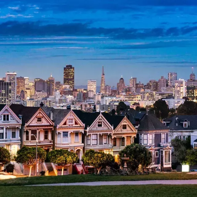 Las famosas Damas Pintadas de Alamo Square aparecen fotografiadas ante el horizonte de 贝博体彩app al anochecer.